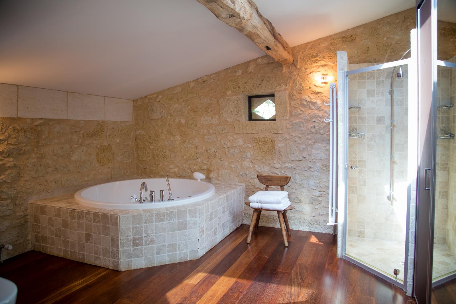 Bathroom with bath, chair and shower at La Colline Bleue in South West France