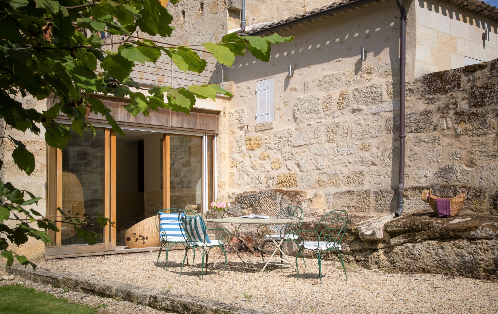 Patio with dining table, chairs and flowers at La Colline Bleue in South West France