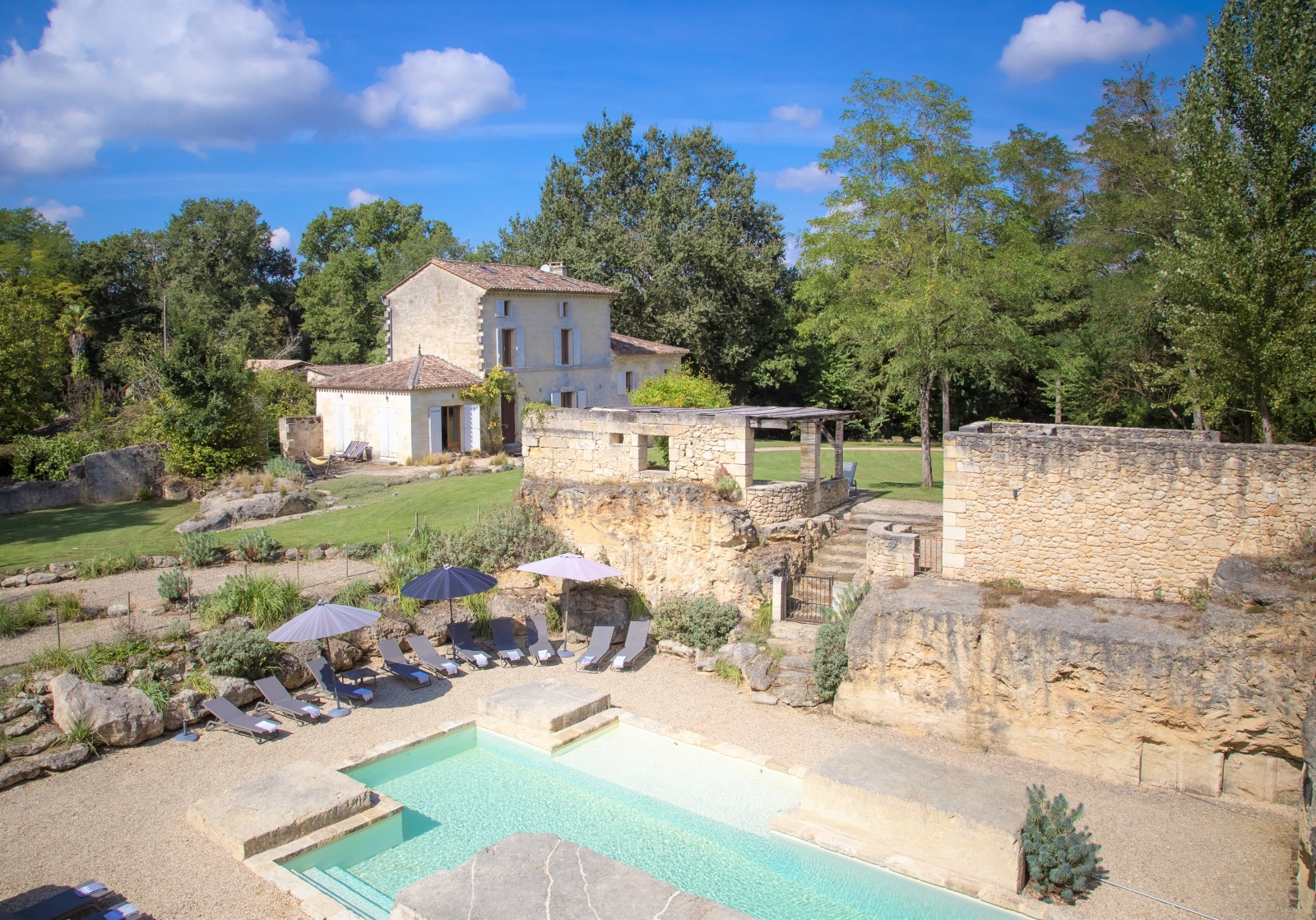 View of villa, gardens, pool and pool area at La Colline Bleue in South West France