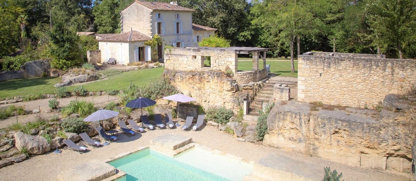 View of villa, gardens, pool and pool area at La Colline Bleue in South West France