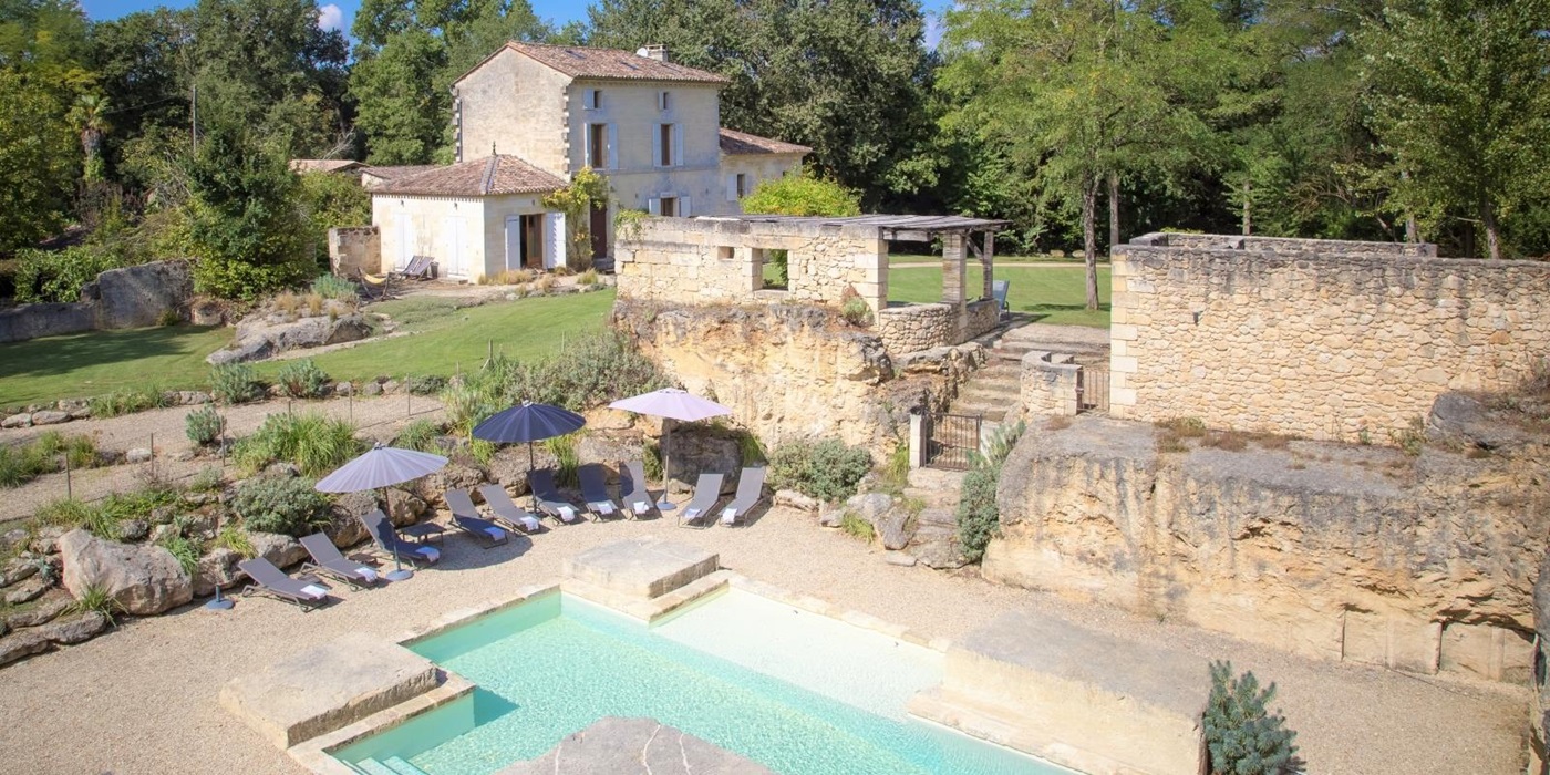 View of villa, gardens, pool and pool area at La Colline Bleue in South West France