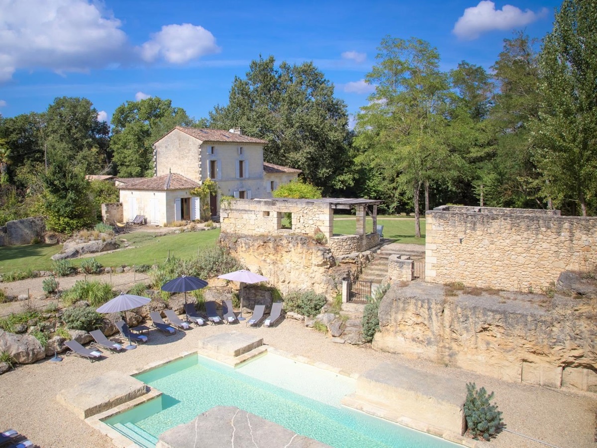 View of villa, gardens, pool and pool area at La Colline Bleue in South West France