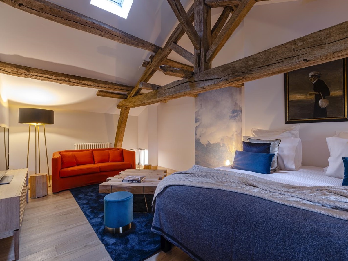 Bedroom with double bed and beamed ceiling at Le Clos Colombier in France
