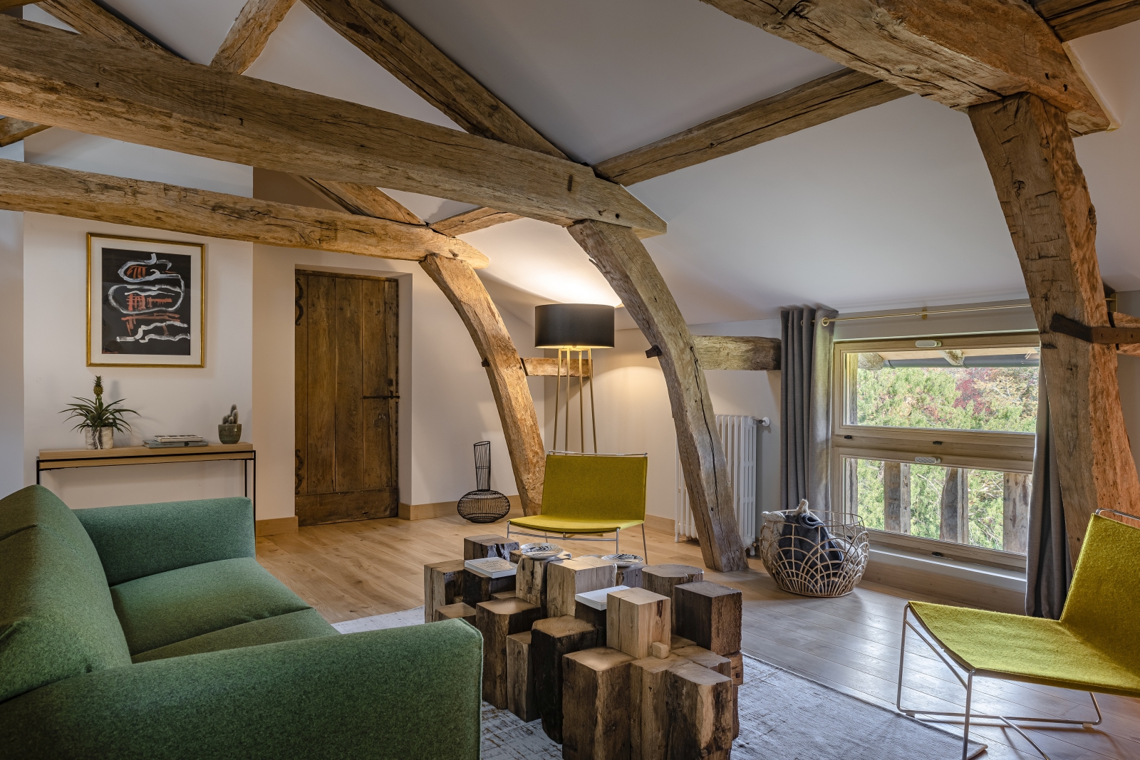 Seating area in bedrom with beamed ceiling at Le Clos Colombier in France