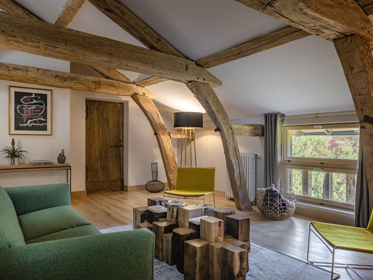 Seating area in bedrom with beamed ceiling at Le Clos Colombier in France