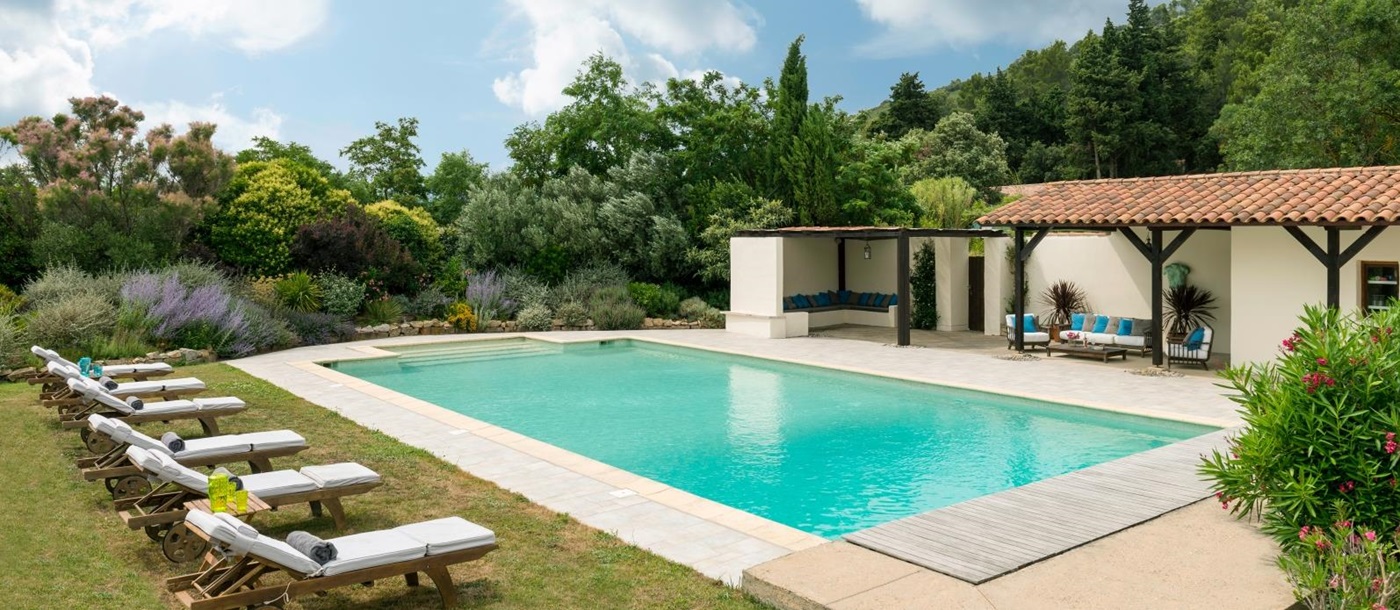 Swimming pool with sun loungers, comfy chairs and lavender at Le Clos des Vignes in South West France