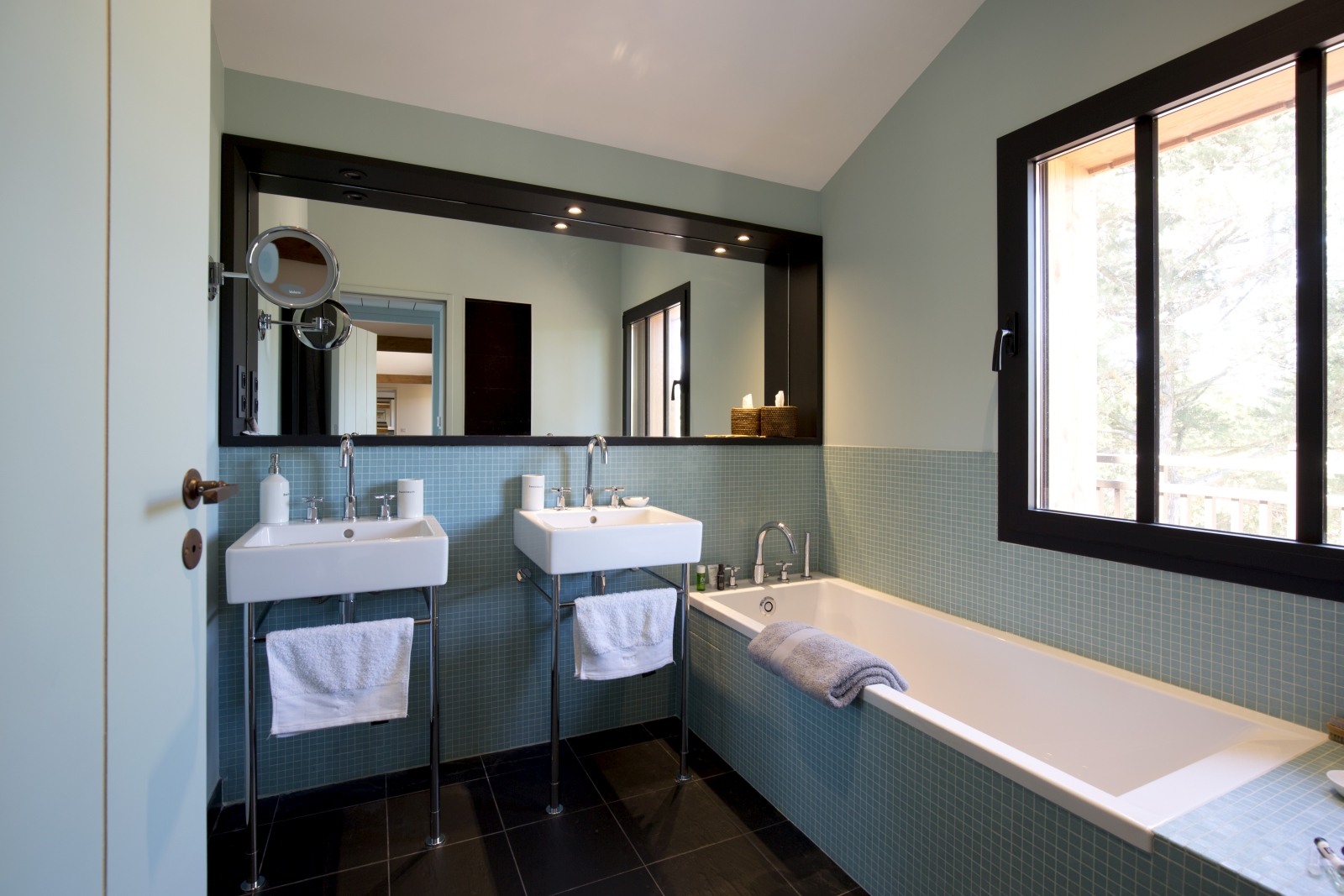 Bathroom with two sinks, large mirror, bathtub and window at Villa Carmen in South West France
