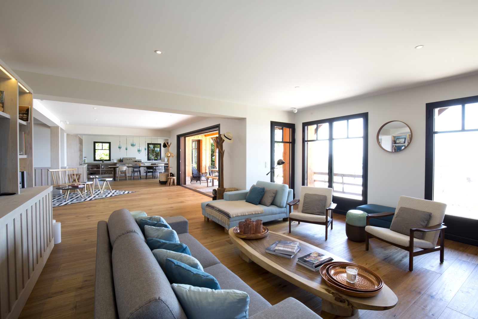 Living room with sofa, chaise longue, armchairs, coffee table and patio doors at Villa Carmen in South West France
