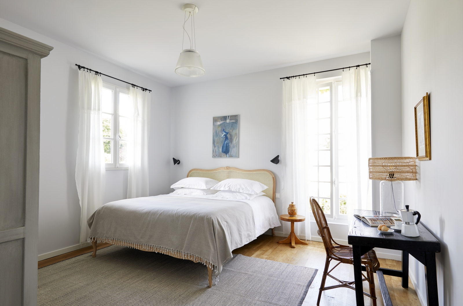 Double bedroom with large windows and desk at luxury villa Pomeira in the South West of France