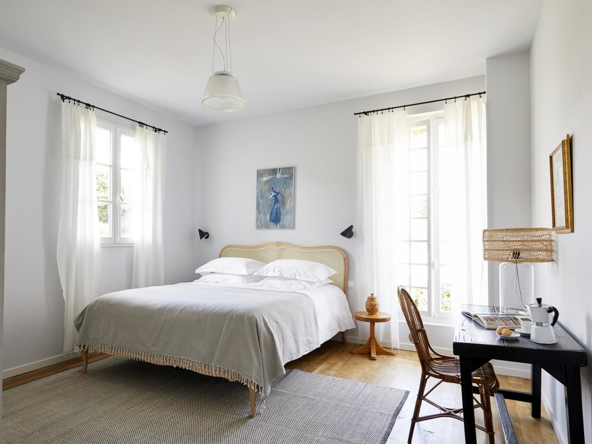 Double bedroom with large windows and desk at luxury villa Pomeira in the South West of France