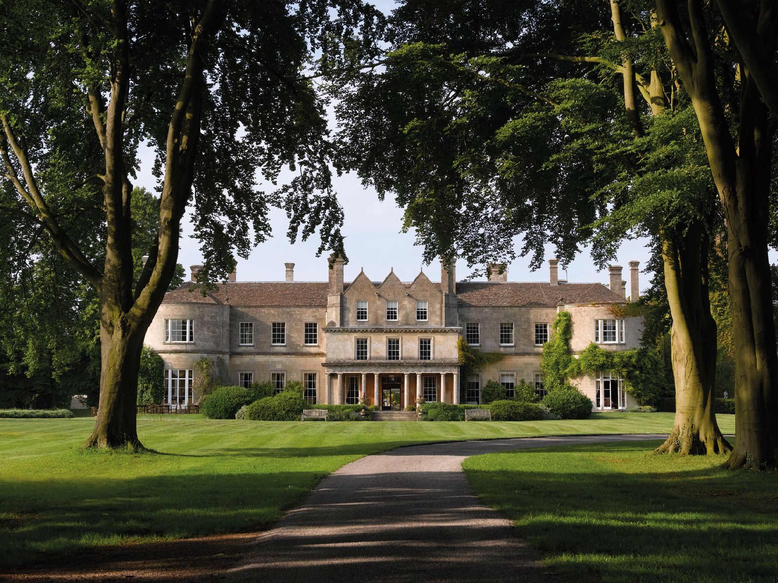 Tree lined avenue leading to Lucknam Park hotel in the Cotswolds England