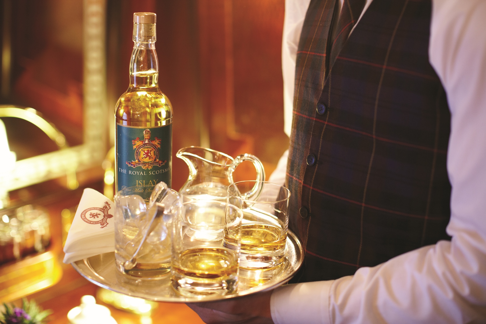 Bartender serving whiskey in the Royal Scotsman, Scotland