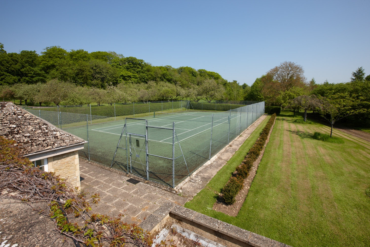 Tennis court of Living room with fireplace in Cornwell Manor, Cotswolds