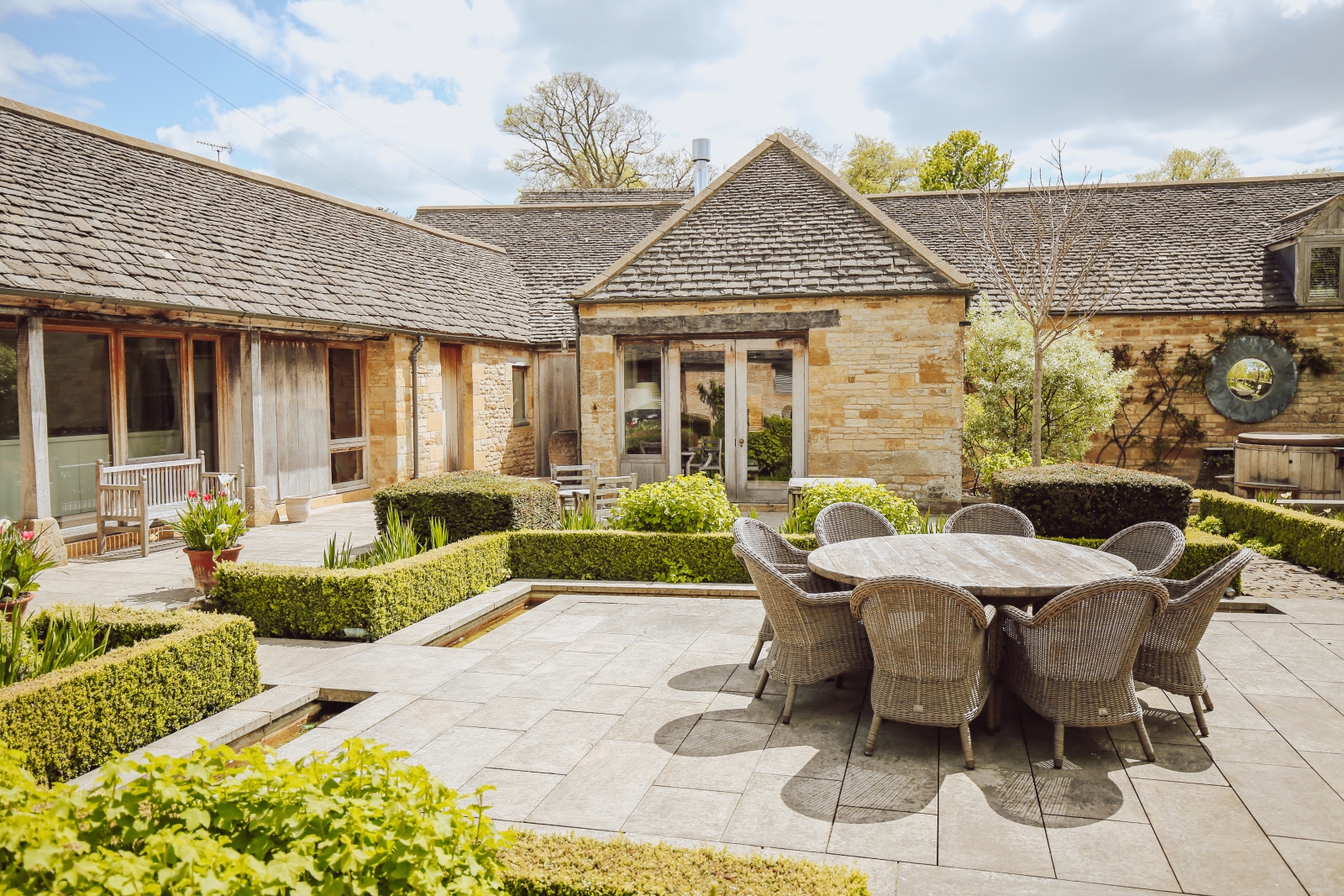 Terrace seating area in the courtyard of Temple Guiting Manor Barn in the Cotswolds, England