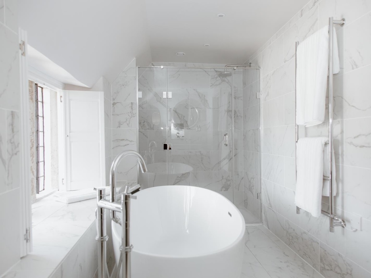 All-marble bathroom with freestanding bathtub at English luxury villa Temple Guiting Manor