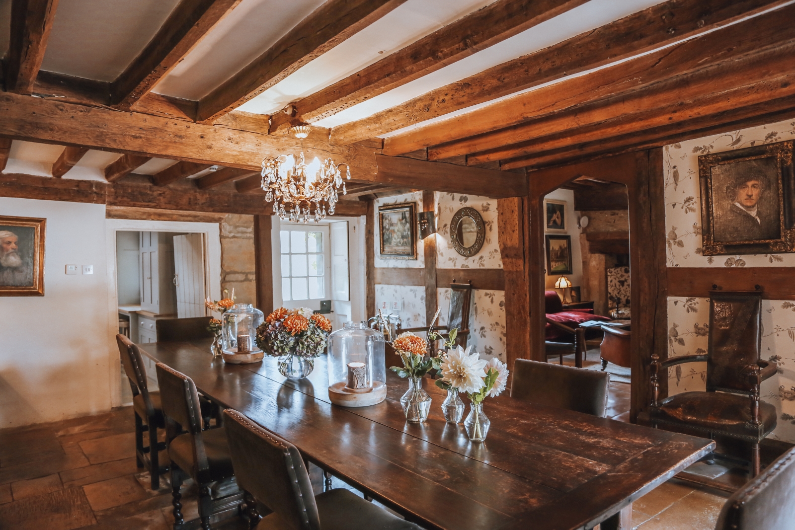 Extensive rustic dining room with exposed wooden beams at Temple Guiting Manor, Cotswolds, England
