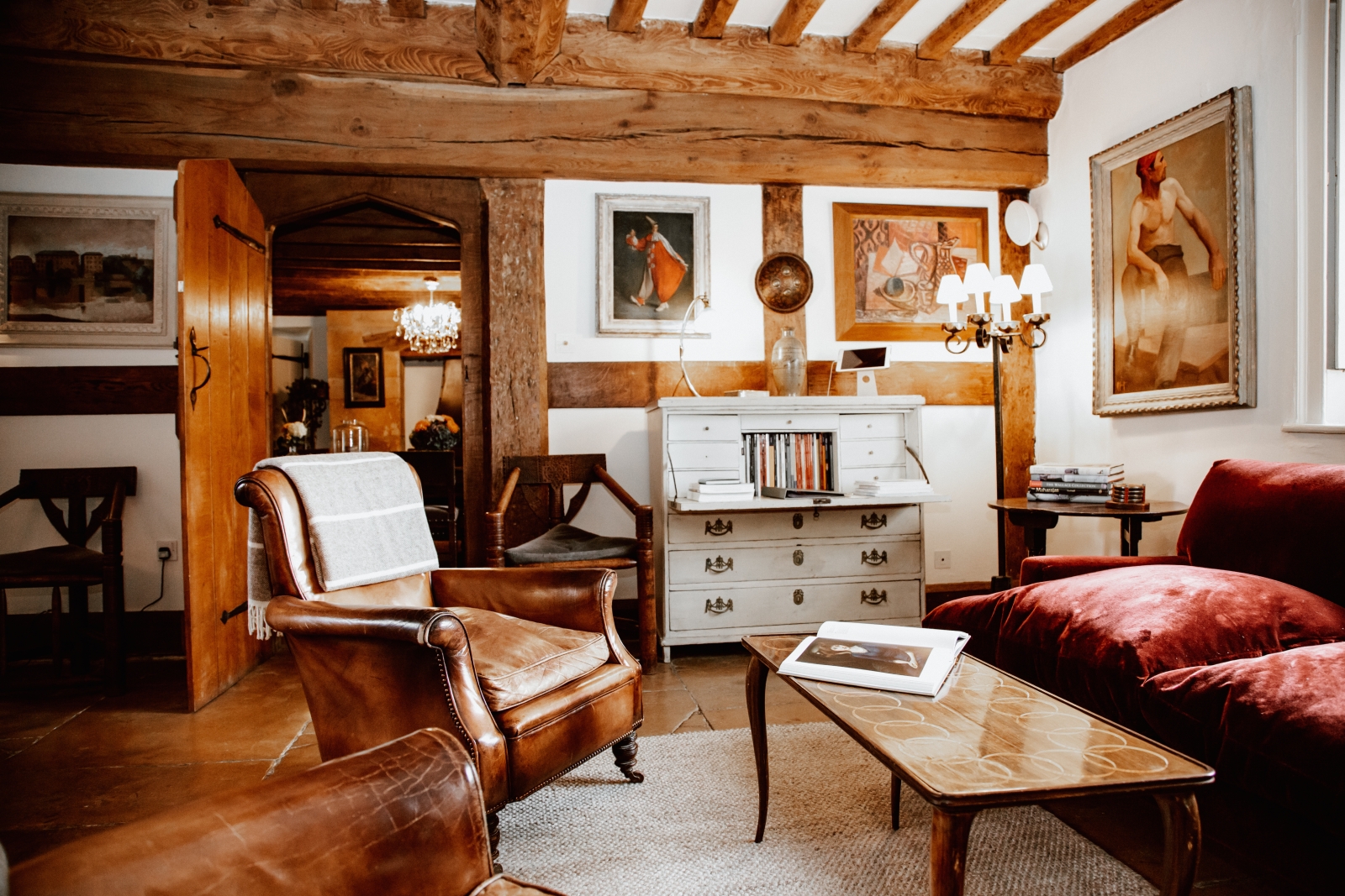 Comfortable rustiv sitting room with leather armchairs at Temple Guiting Manor, luxury villa in the Cotswolds, England