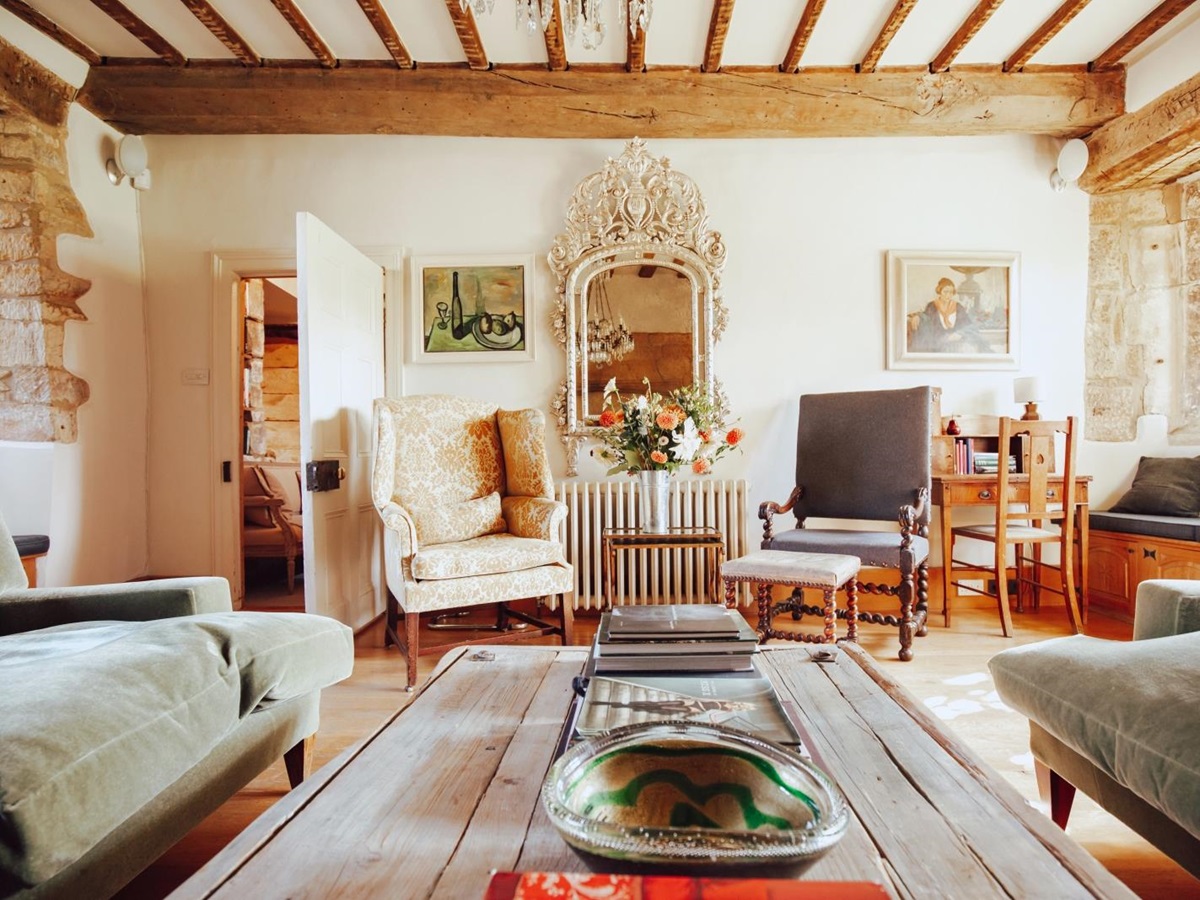 Traditional country-style sitting room with comfortable sofas and armchairs at luxury villa Temple Guiting Manor in the Cotswolds, England