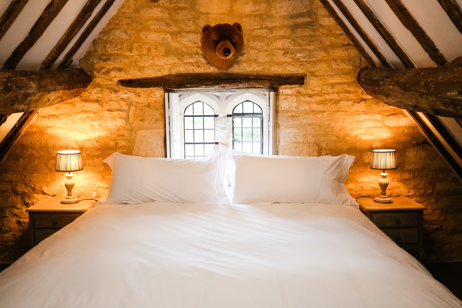 Bedroom with double bed, bedside tables and lamps at Temple Guiting Manor in the Cotswolds, England