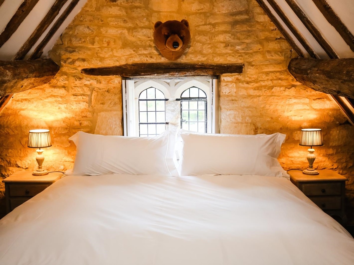 Bedroom with double bed, bedside tables and lamps at Temple Guiting Manor in the Cotswolds, England