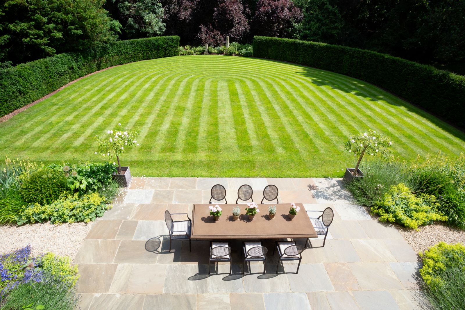 Lawn and patio with dining table at Woodstock Lodge