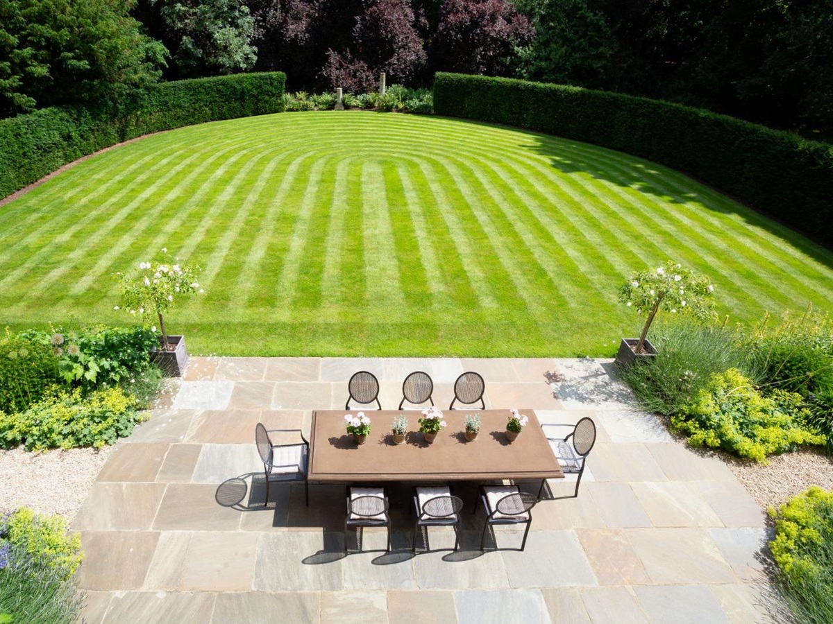 Lawn and patio with dining table at Woodstock Lodge