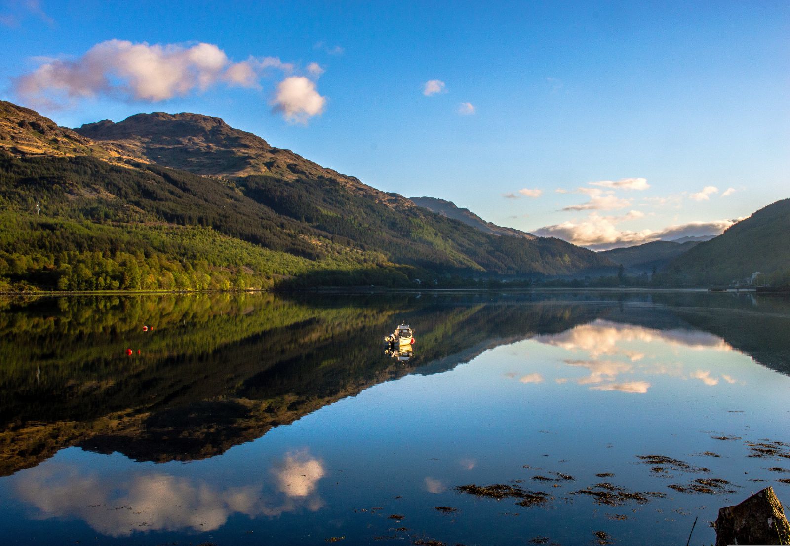 Boat reflected on the waters of Loch Lomond in Scotland
