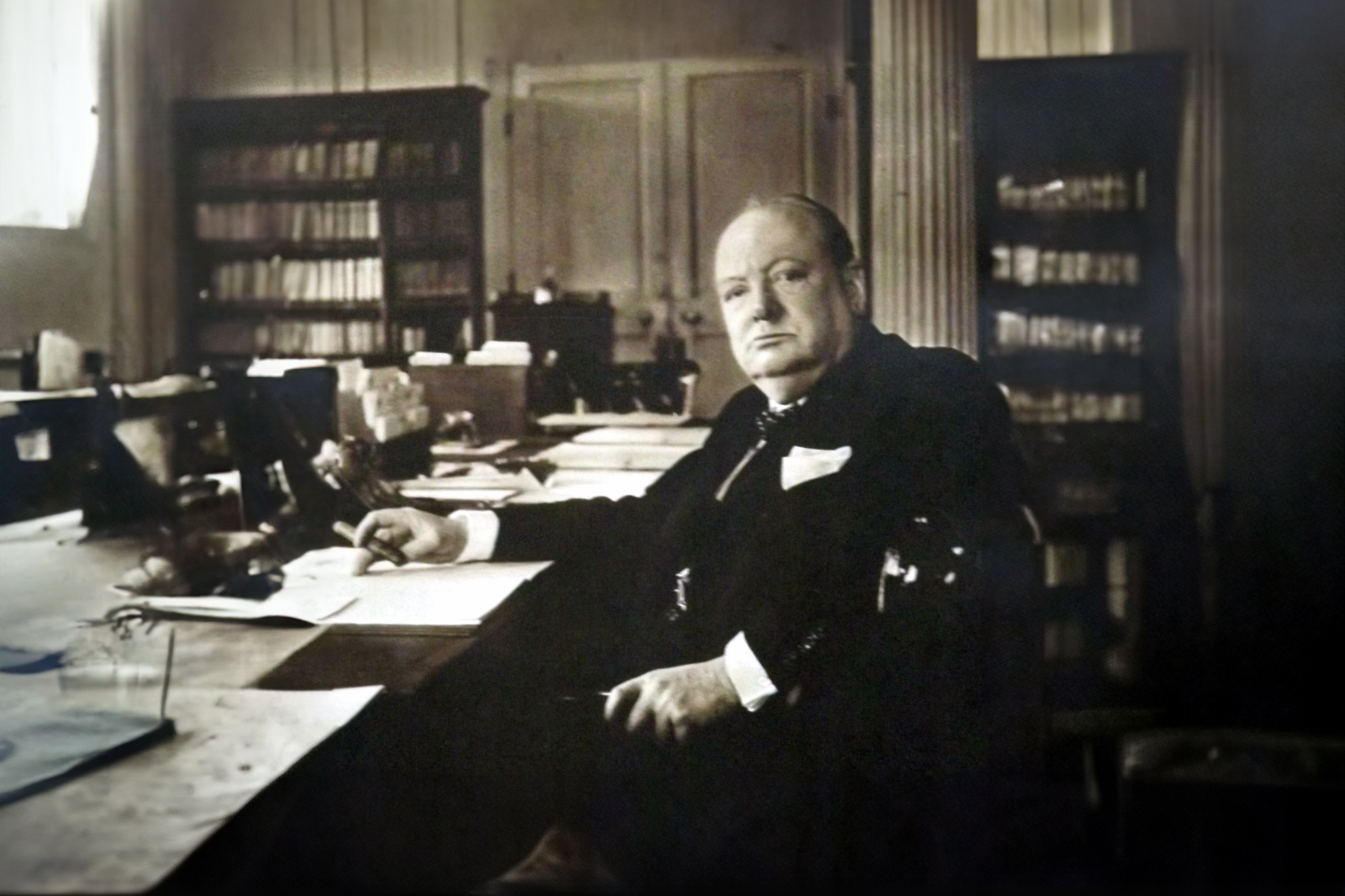 Winston Churchill sat at his desk