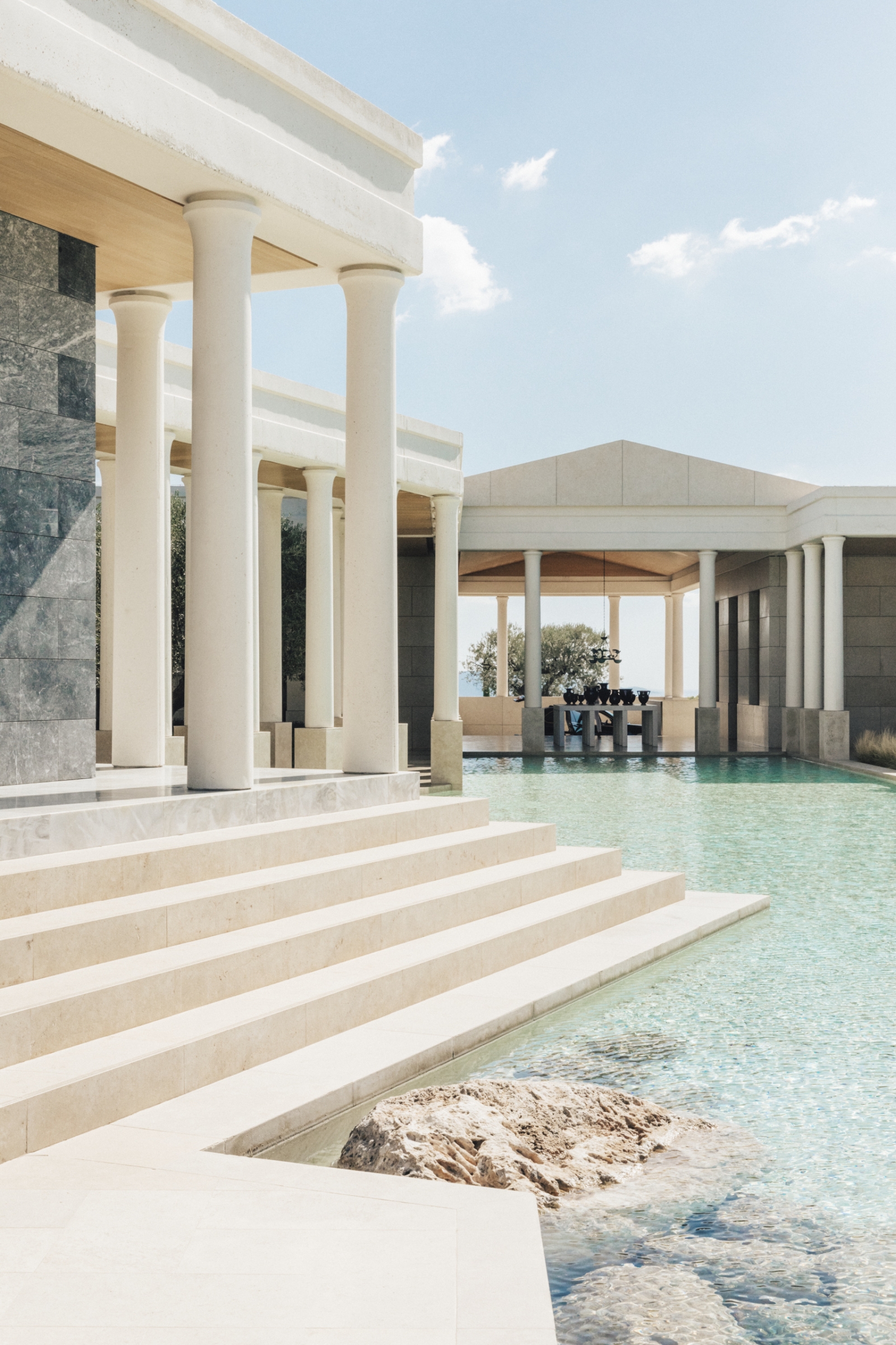 White, ancient greek-style Arrivals Hall with pillars and turquoise pools