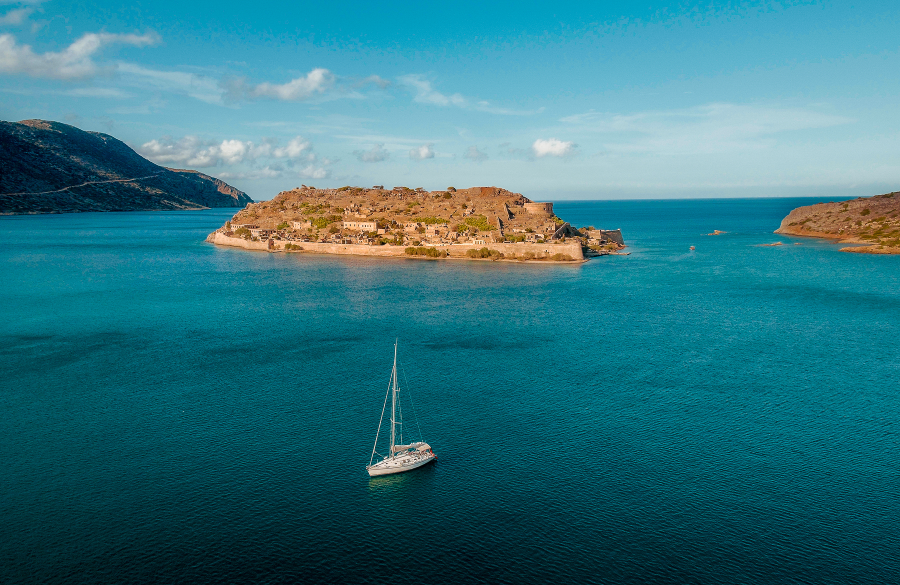 A boat sailing around the ocean at Phāea Blue Palace in Crete