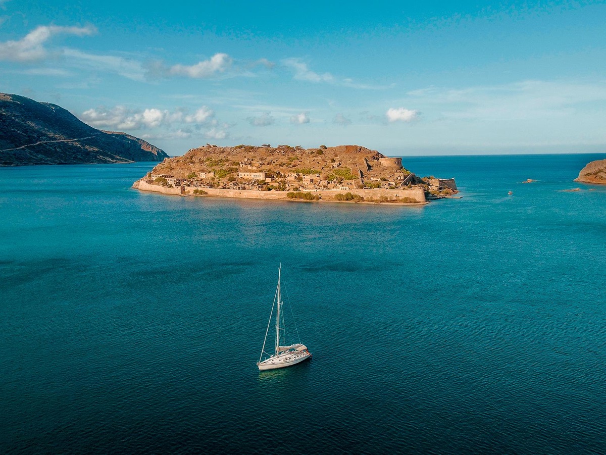 A boat sailing around the ocean at Phāea Blue Palace in Crete