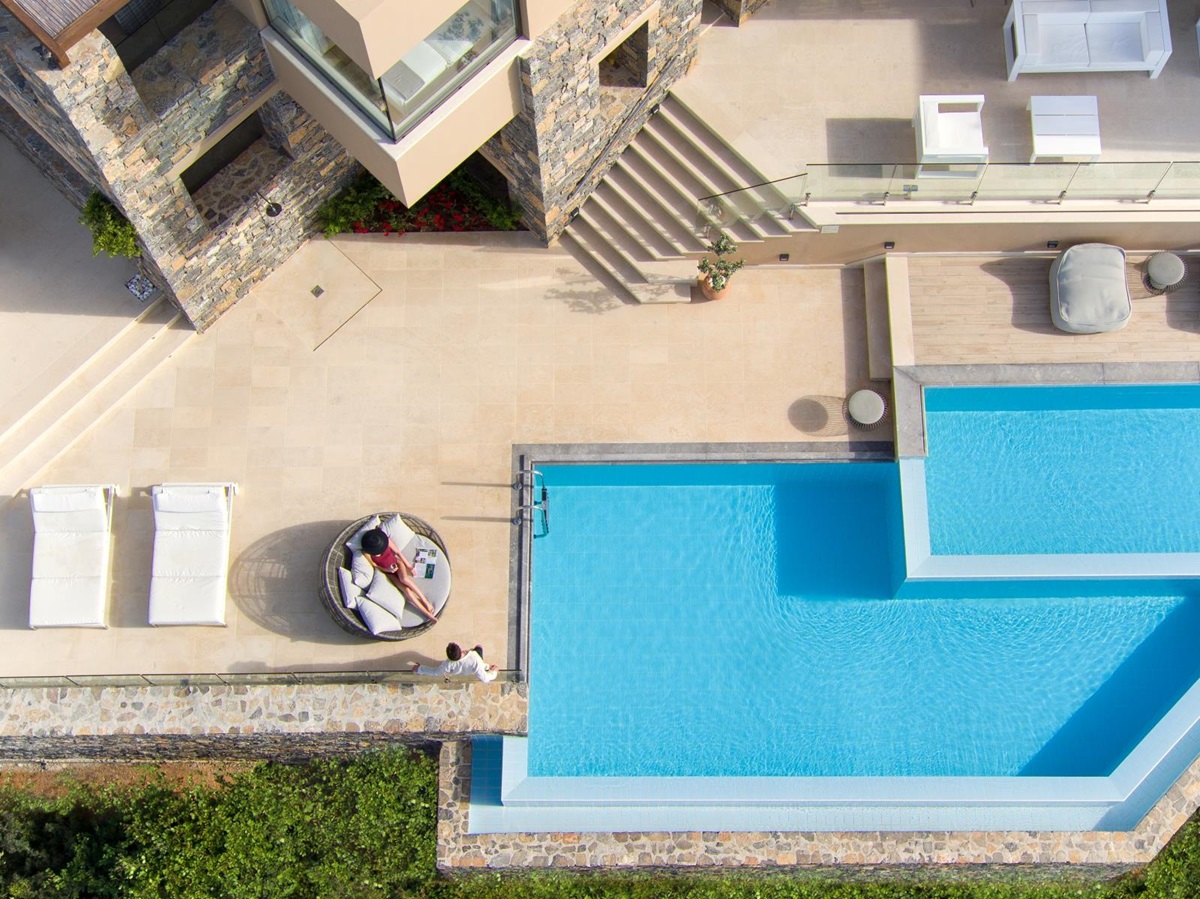 Aerial view of the spacious terrace and pool of a Mansion at luxury resort Daios Cove in Greece