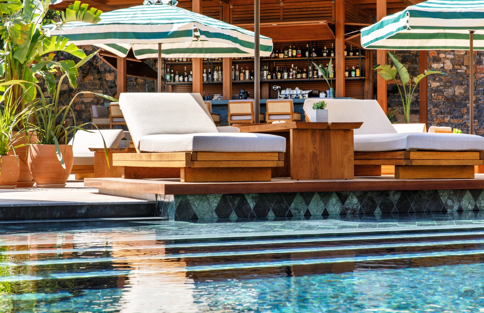 Sun loungers by the pool at luxury resort Daios Cove in Greece