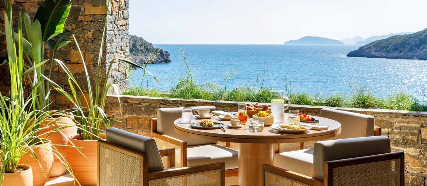 Breakfast on the terrace of Ocean Restaurant with views over the Mediterranean Sea at luxury resort Daios Cove in Greece