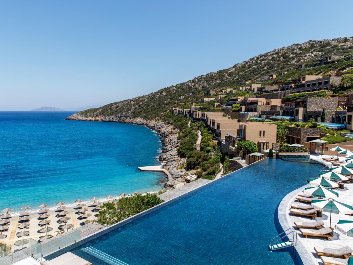 View over the main infinity pool, the beach and the bay at luxury resort Daios Cove in Greece