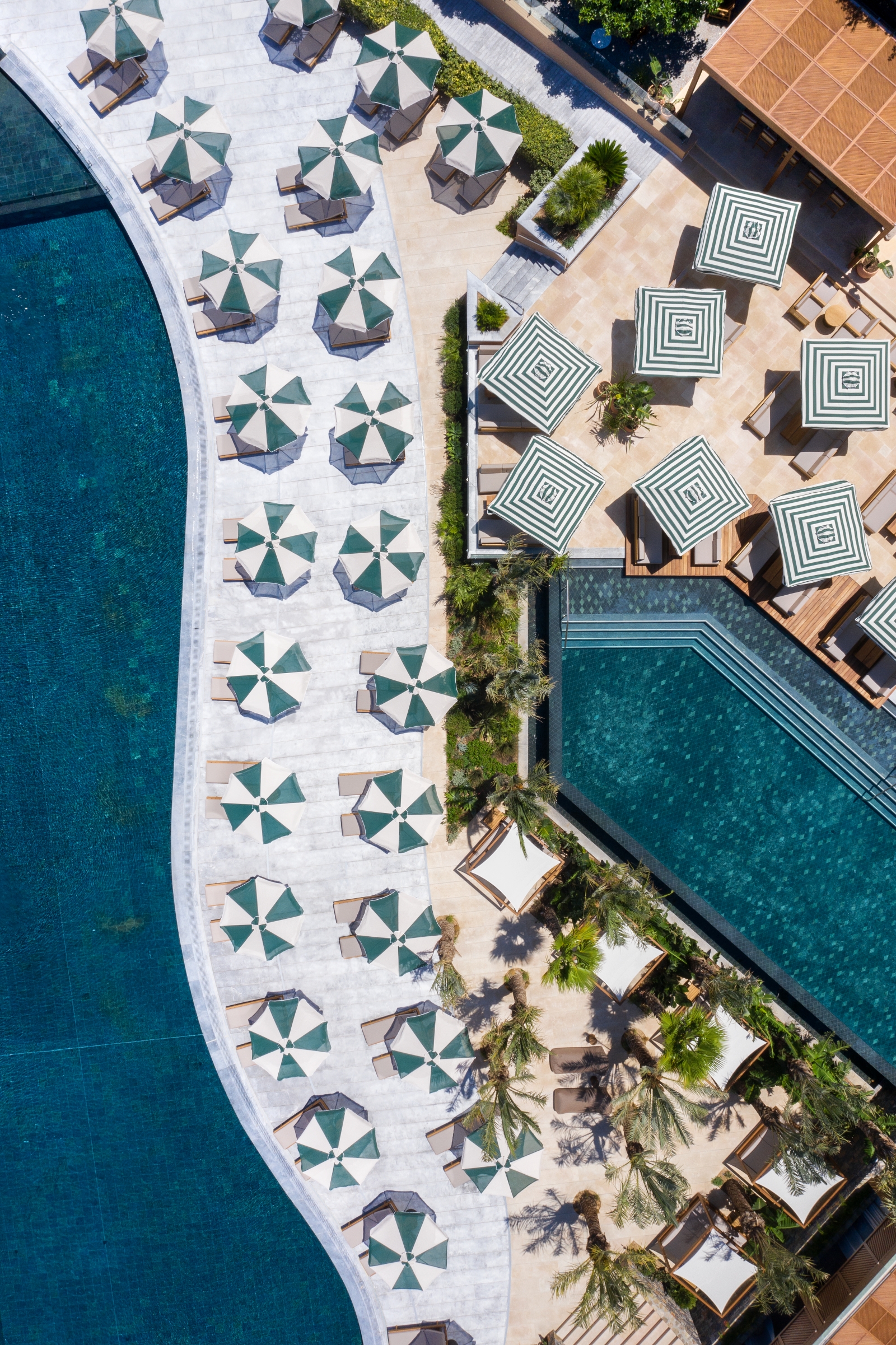 Aerial view of the pools, sunloungers and parasols at luxury resort Daios Cove in Greece