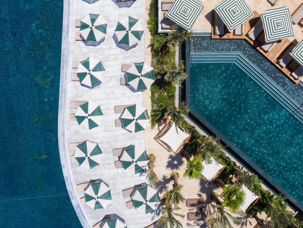 Aerial view of the pools, sunloungers and parasols at luxury resort Daios Cove in Greece