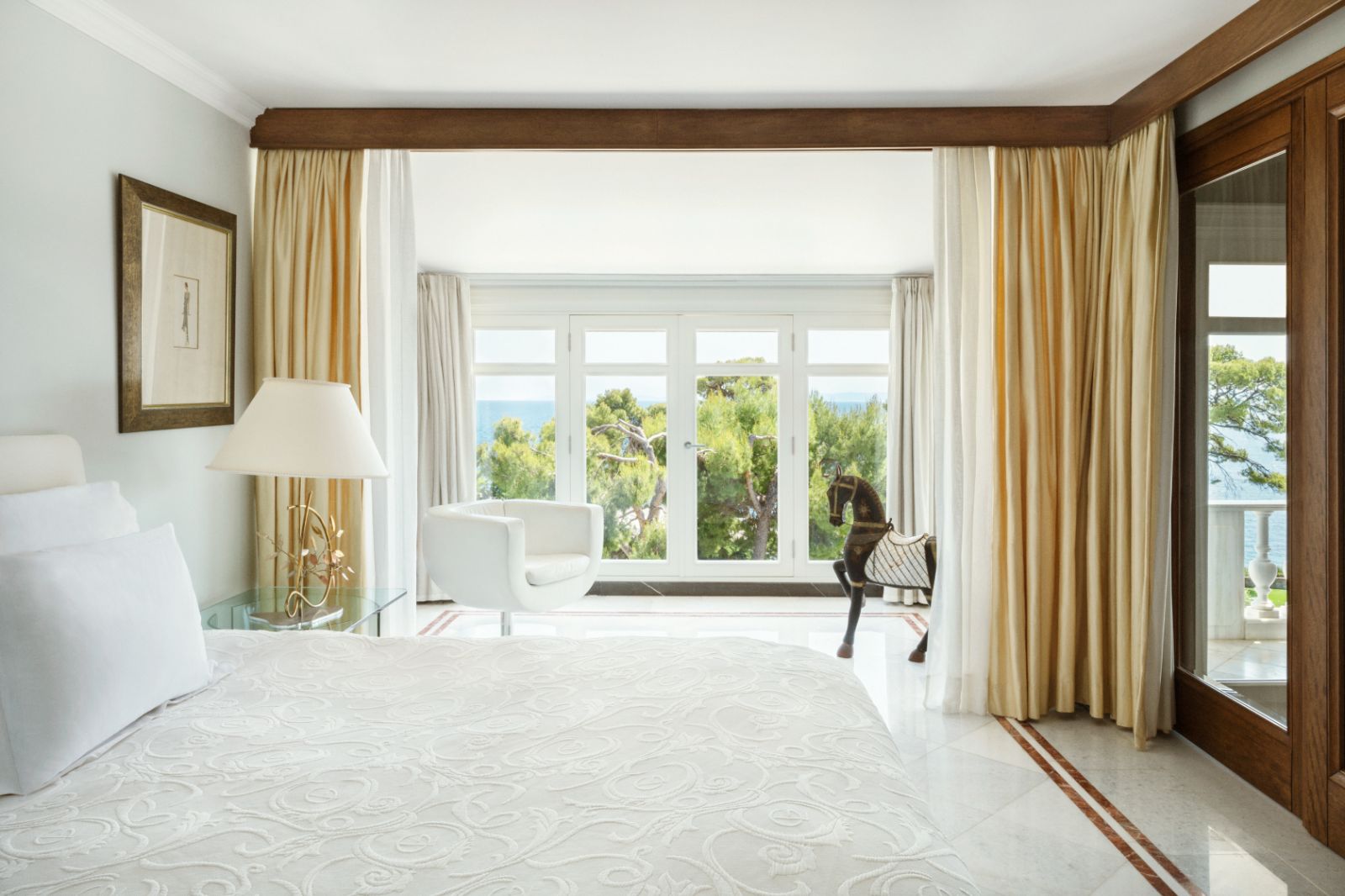 Mediterranean Room at luxury resort Danai Beach in Greece with floor-to-ceiling windows overlooking the gardens and sea