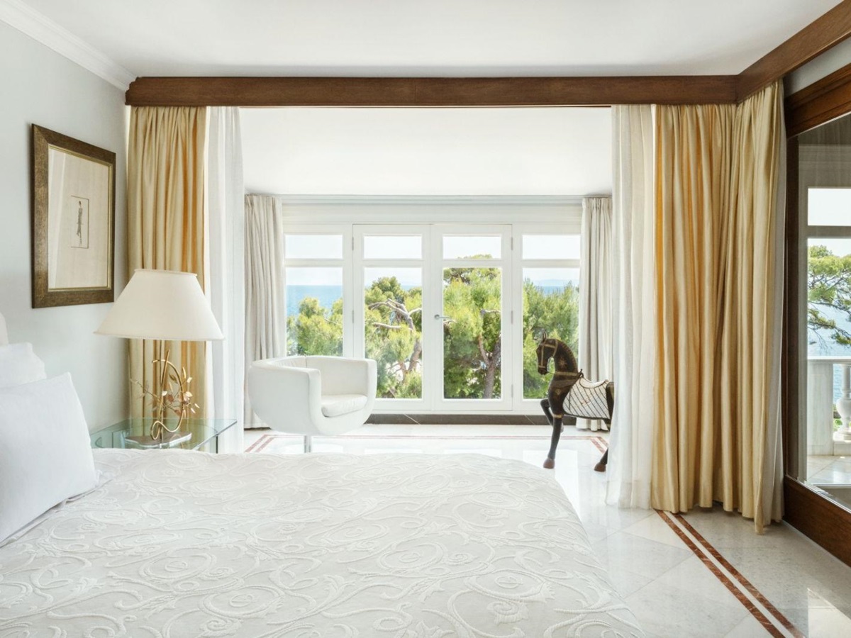Mediterranean Room at luxury resort Danai Beach in Greece with floor-to-ceiling windows overlooking the gardens and sea