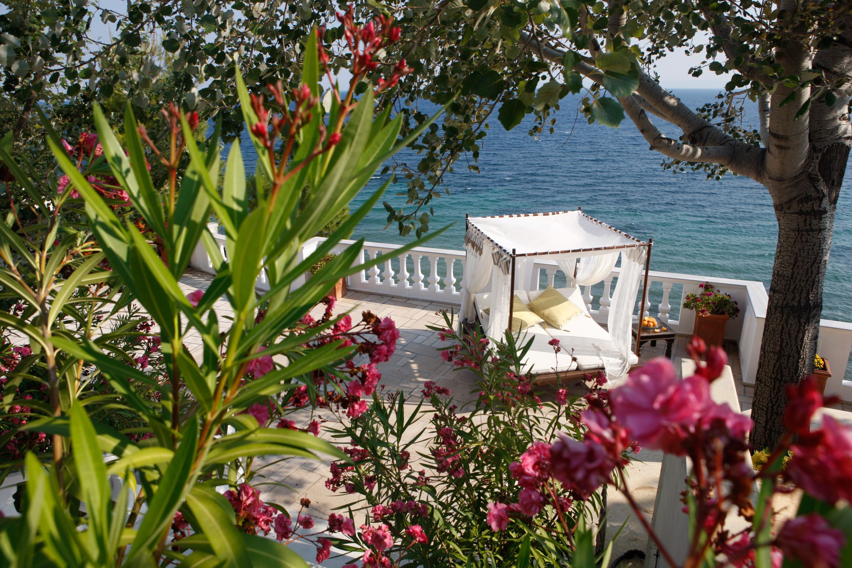 The gardens with an outdoor bed at Danai Beach Resort Villas, Greece