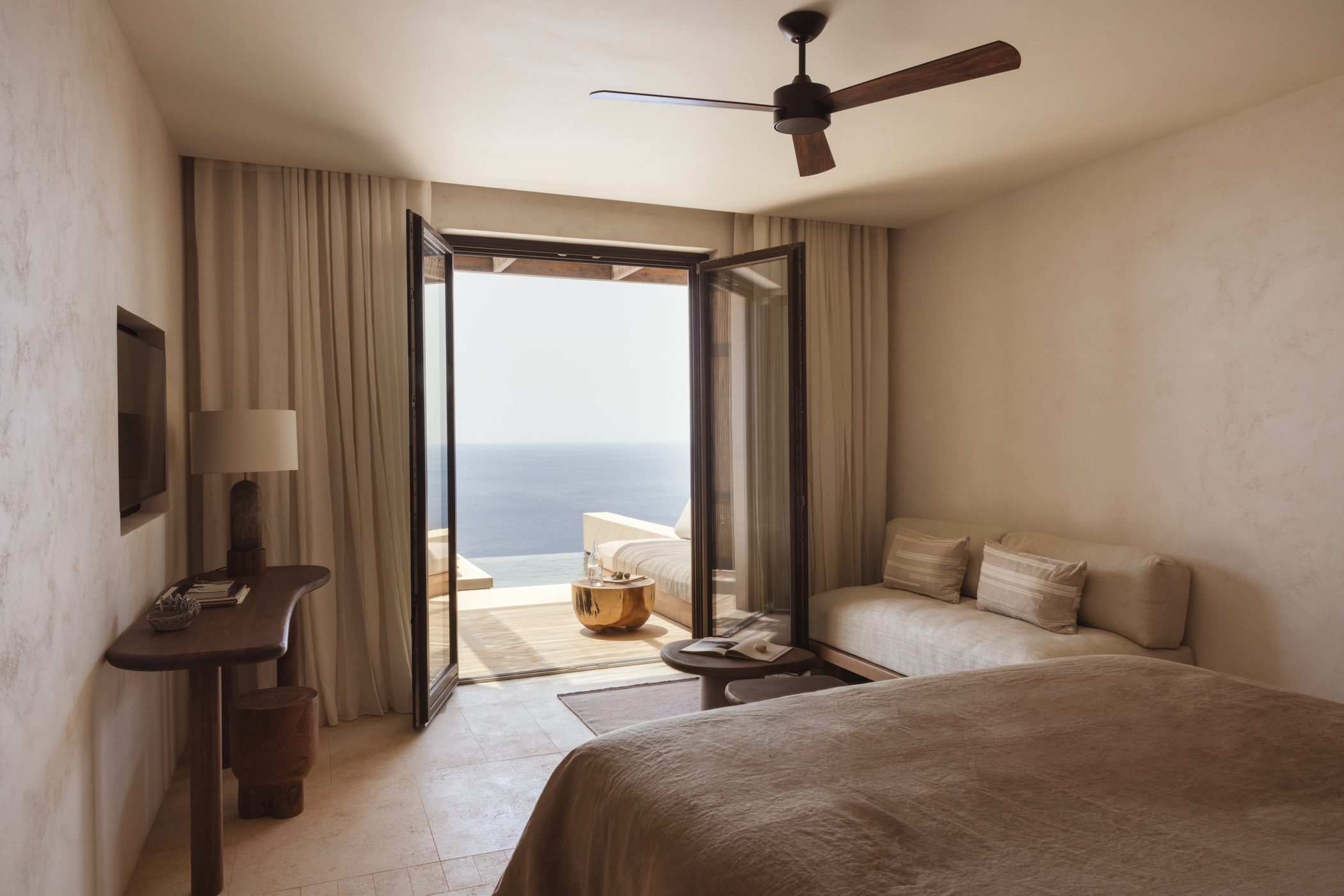 Guest suite bedroom with ocean views at Gundari luxury resort in Greece