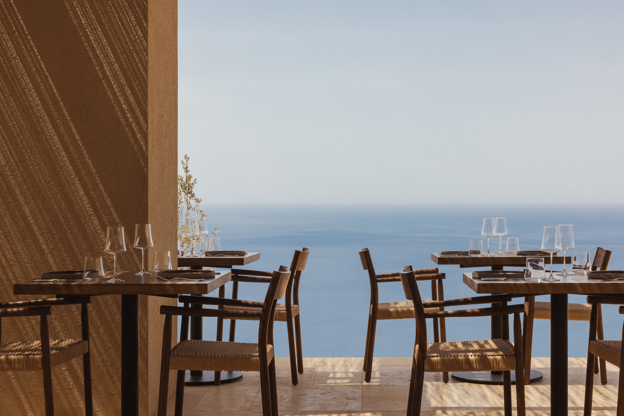 Restaurant tables with ocean views at Gundari luxury resort in Greece