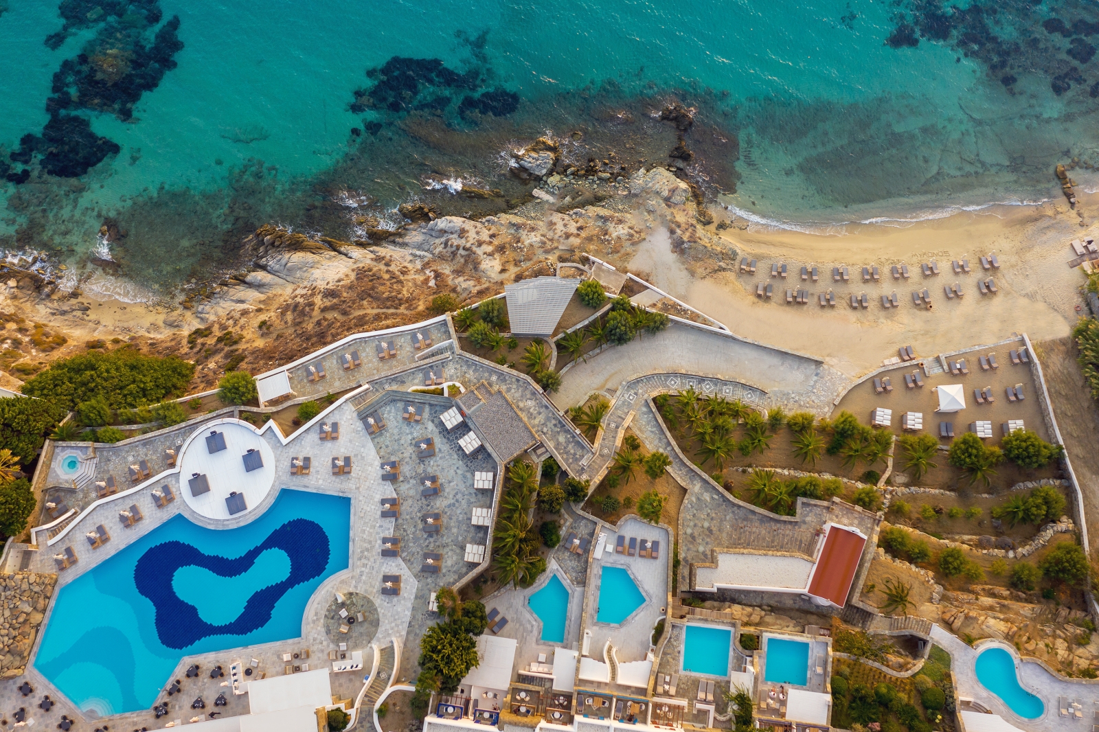 Aerial view over the pools and beach at luxury resort Mykonos Grand, Greece