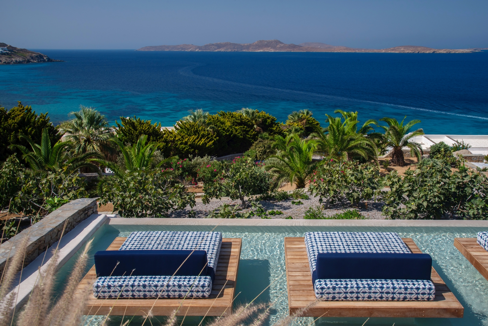Two sunloungers overlooking the Aegean Sea in the spa pool at luxury resort Mykonos Grand, Greece