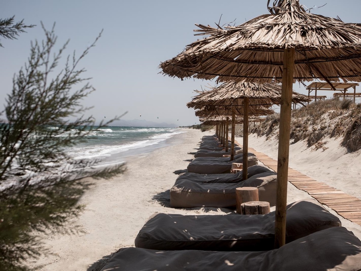 Loungers and parasols on the beach at luxury hotel OKU Kos in Greece