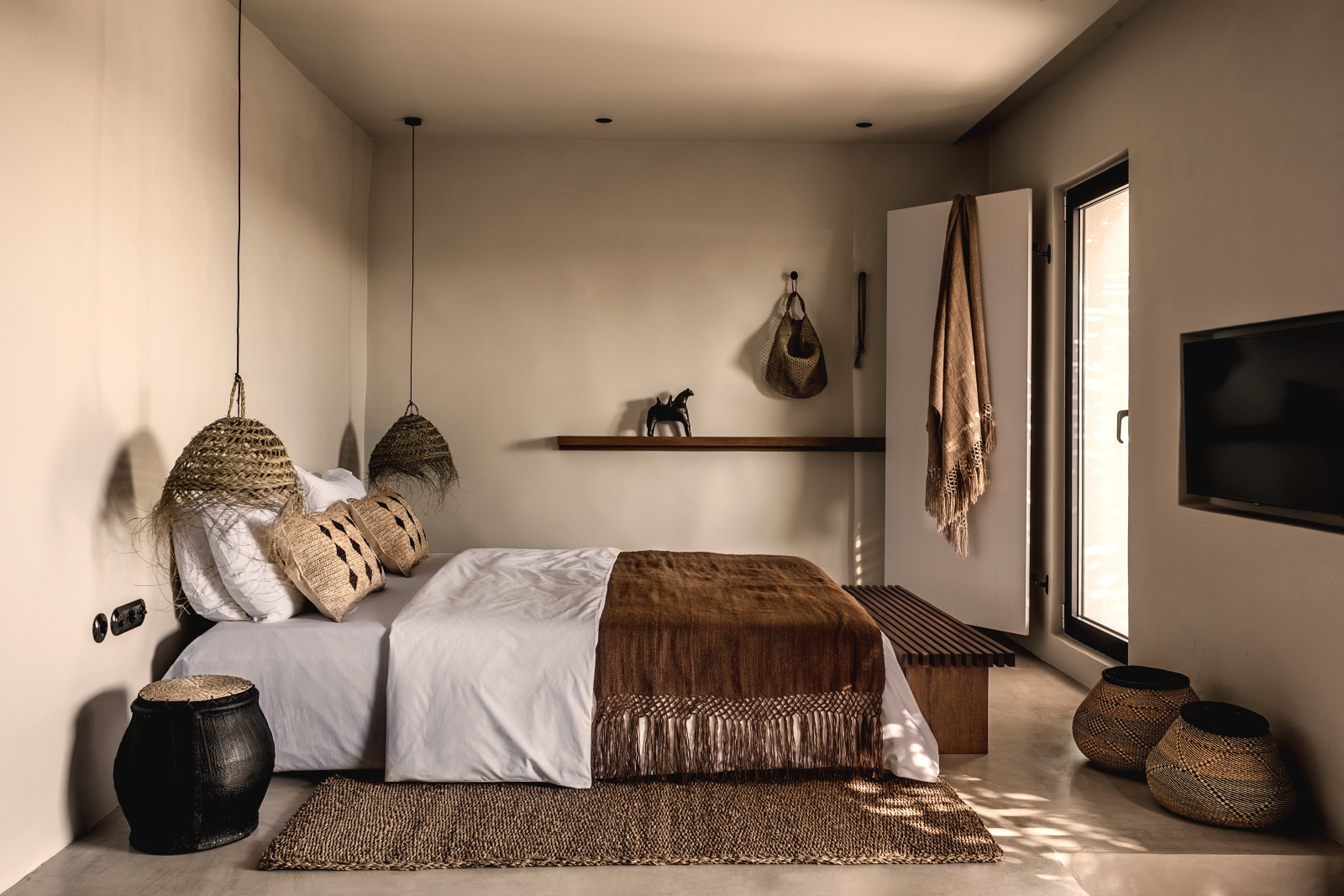 Spacious minimalistic bedroom with earthen colour scheme at luxury hotel OKU Kos in Greece
