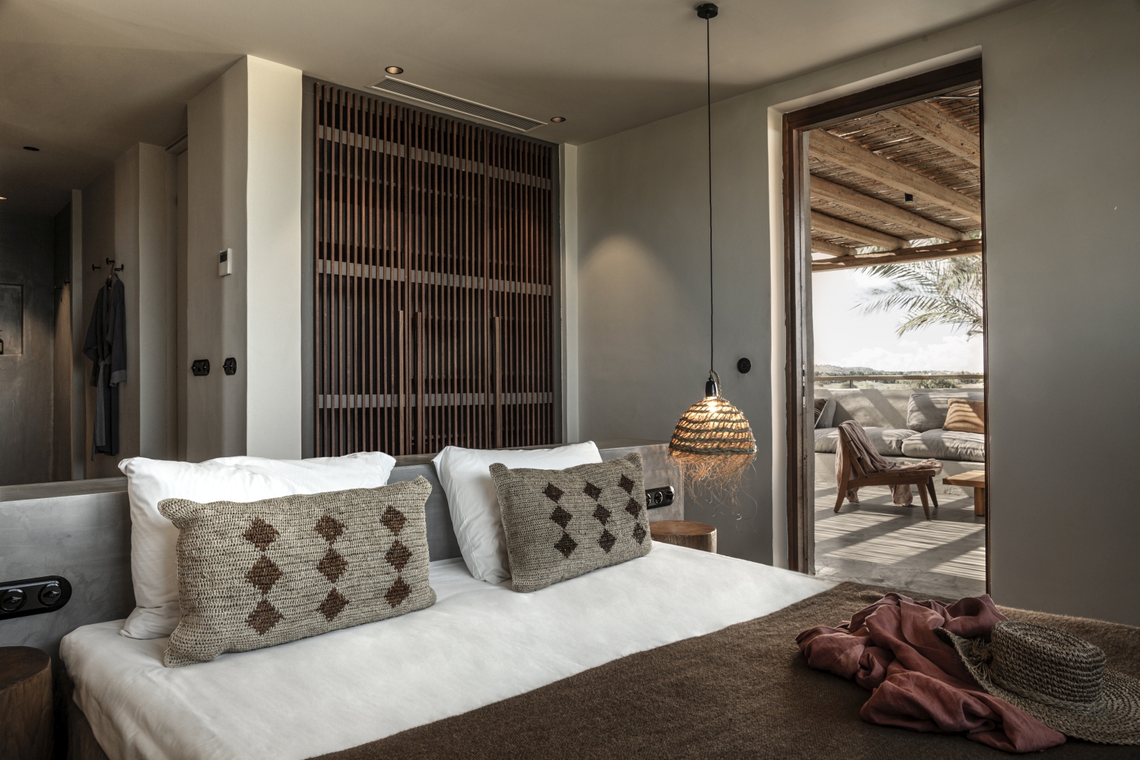 Bedroom with private terrace and earthen colour scheme at luxury hotel OKU Kos in Greece
