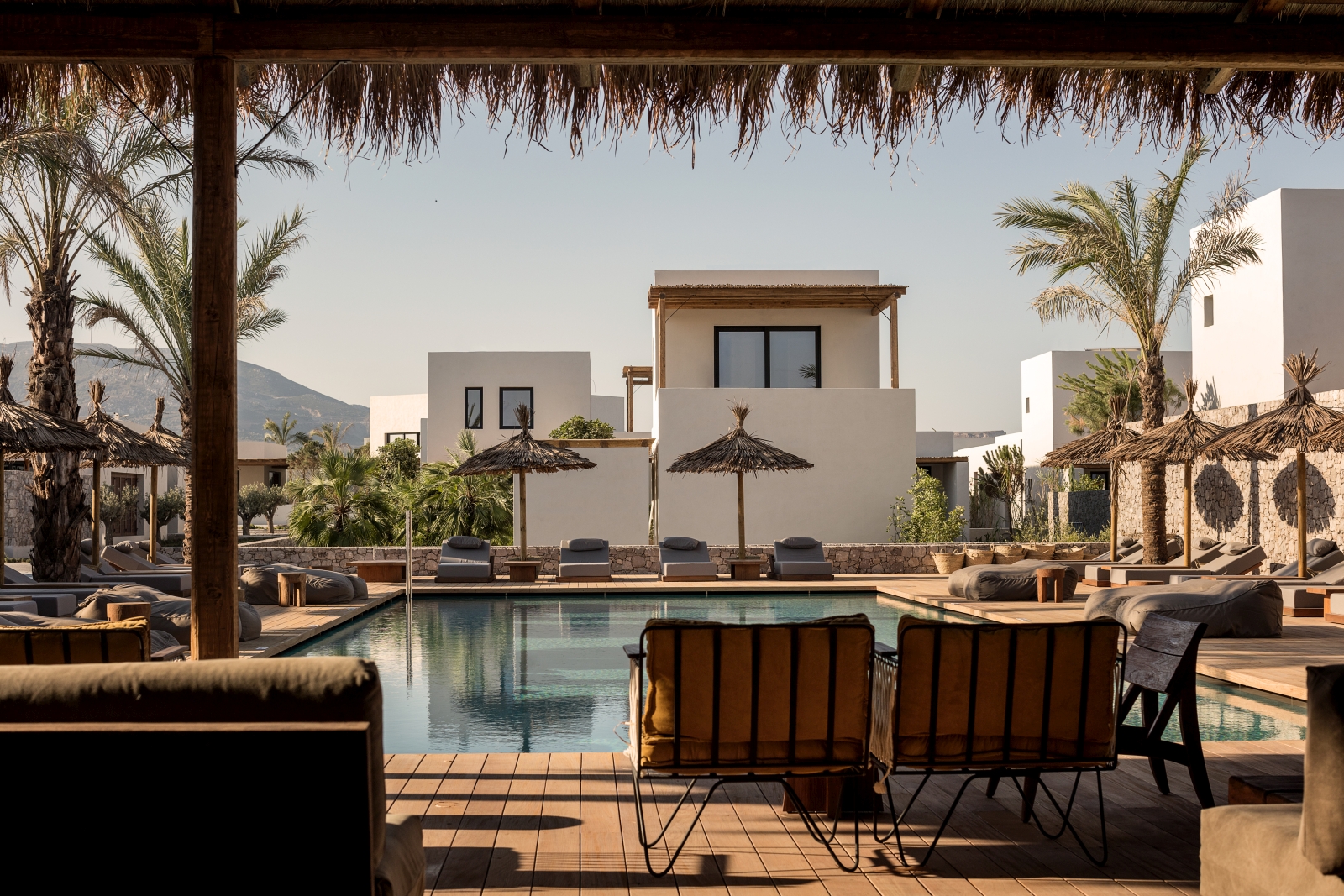 Pool with plenty of seating, loungers and parasols at luxury hotel OKU Kos in Greece