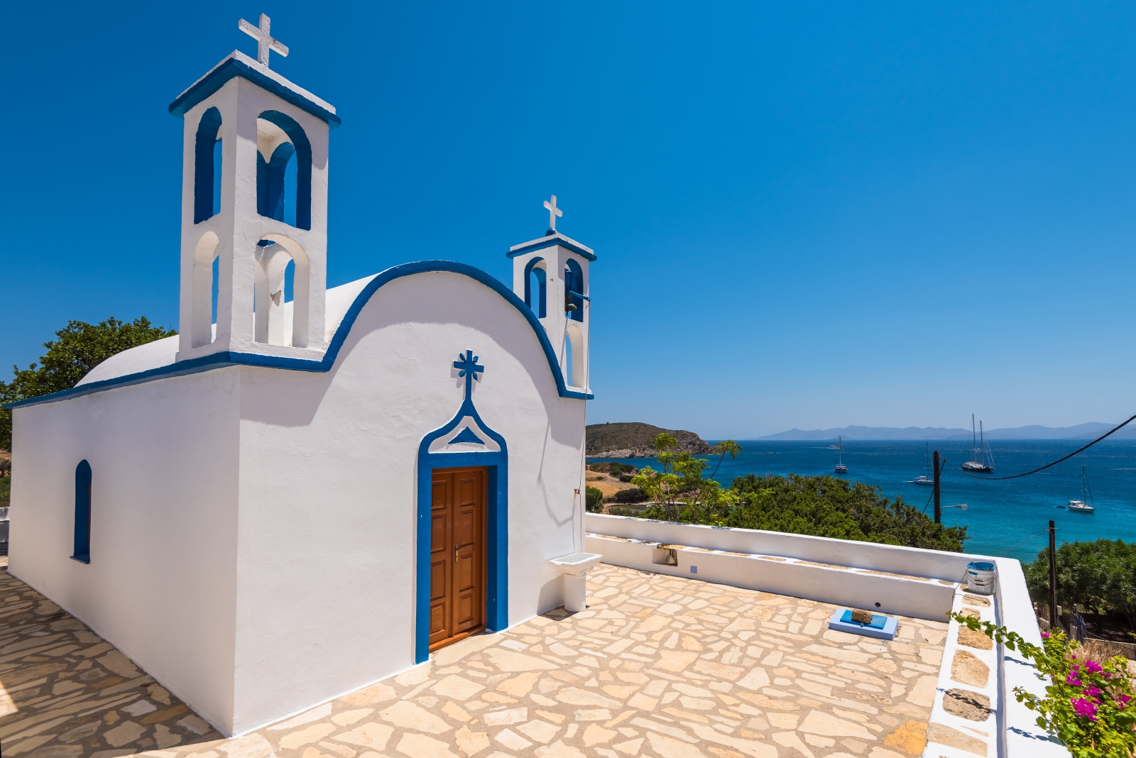 Blue and white chapel on a hill overlooking the sea