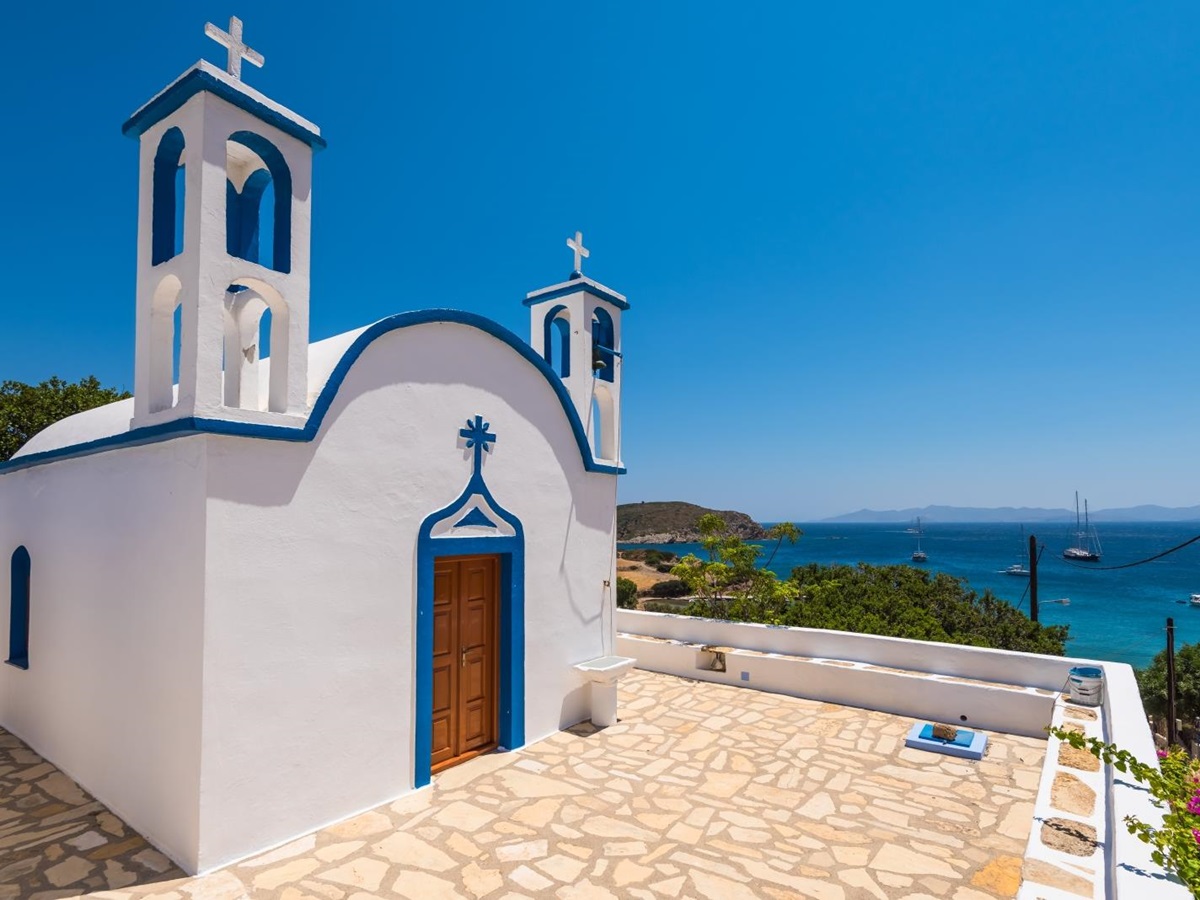 Blue and white chapel on a hill overlooking the sea